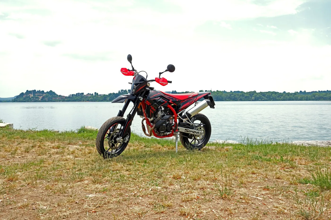 Motocykl SWM supermoto zaparkovaný u jezera